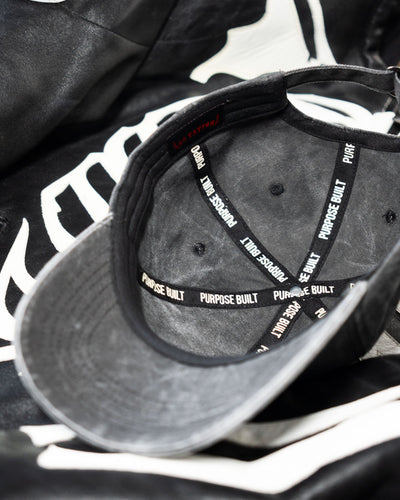 Gray cap with 'Purpose Built' branding on a black and white background