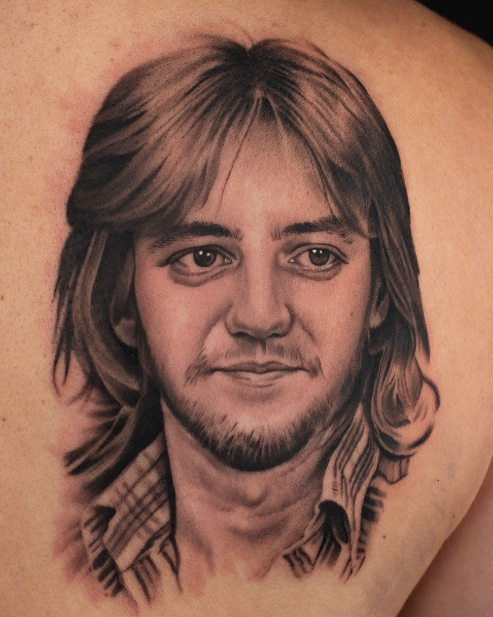 Black and grey realism tattoo of a father’s portrait with detailed facial features on the chest